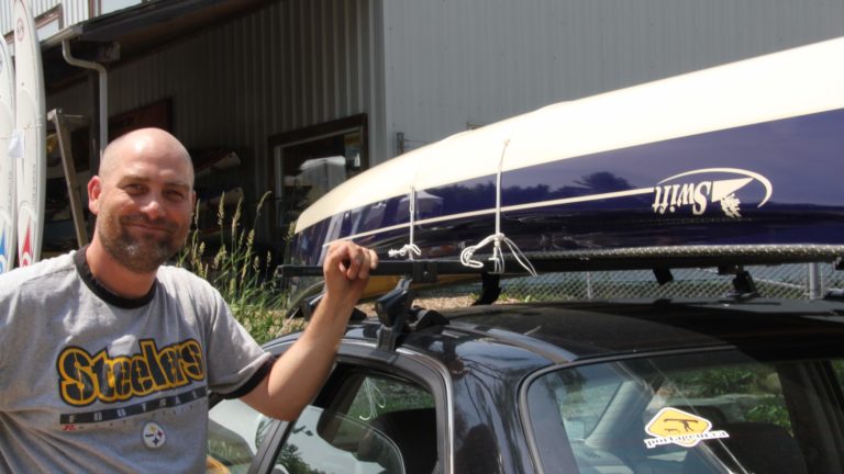 smiling man poses with his new canoe