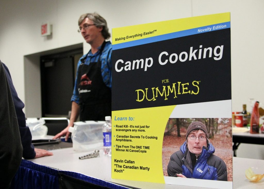 Kevin Callan behind a present given to him by Aluminum Chef competitor Marty Koch - a poster for what Marty assumed was Kevin's new cookbook, Camp Cooking for Dummies. 