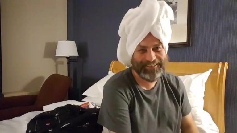 Preston wearing a towel on his head in a hotel room