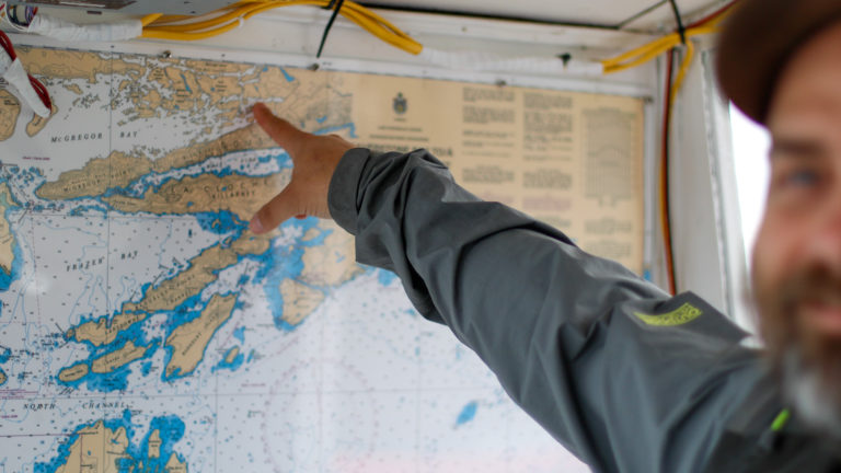 Preston points to a map of Killarney within a water taxi from Killarney Outfitters