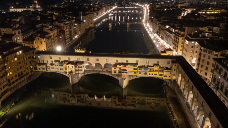 Drone view of Ponte Vecchio and Arno River at night, Florence, Italy