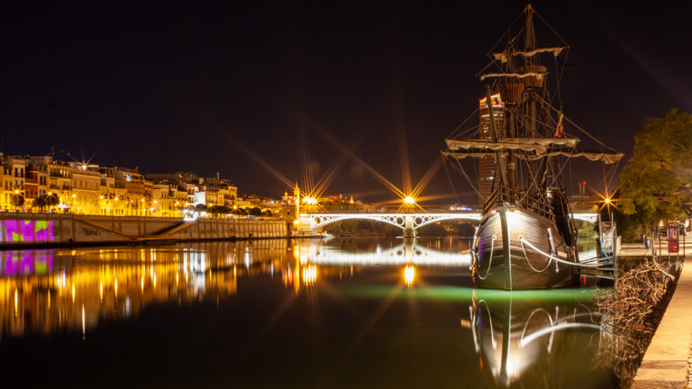 Guadalquivir river at night with a galleon in the foreground